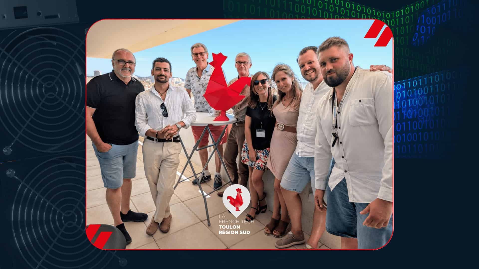 Photo de groupe sur une terrasse ensoleillée réunissant plusieurs membres de l’écosystème French Tech Toulon Région Sud autour d’une statue de coq rouge.